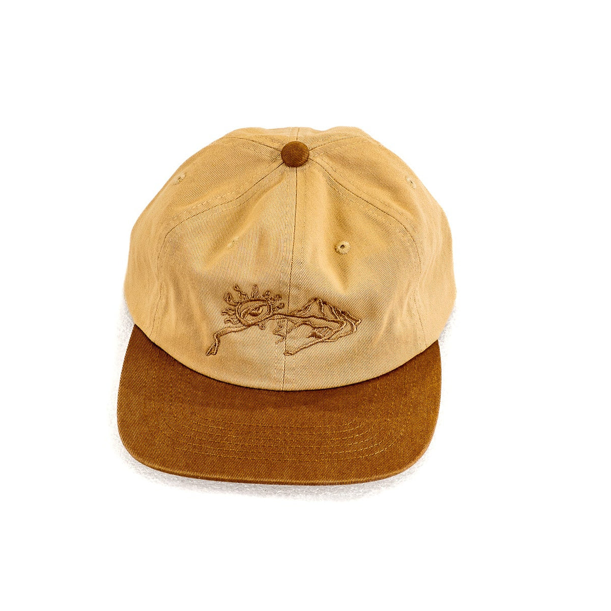 A two-tone baseball cap with a light tan crown and a darker brown flat visor, featuring a small embroidered mountain and sun design on the front.